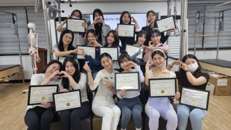 매직바디 정규과정 수료생들이 자격증을 들고 기념 촬영하는 모습